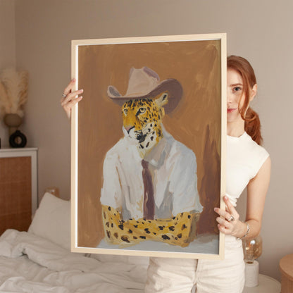 A woman holds up a framed painting of a leopard wearing a cowboy hat.