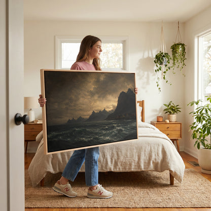 Travel canvas wall art showing lit red houses on a rocky Norwegian shore below jagged peaks with a dark sea in the foreground