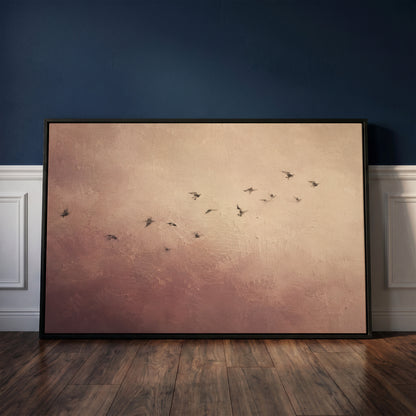 Neutral canvas wall art showing a scattered flock of small dark birds flying across a dusty rose and cream ground