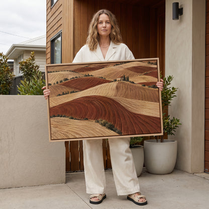 Tuscan hills canvas wall art showing rolling ploughed clay hills in red and cream with a small farmhouse on a distant ridge
