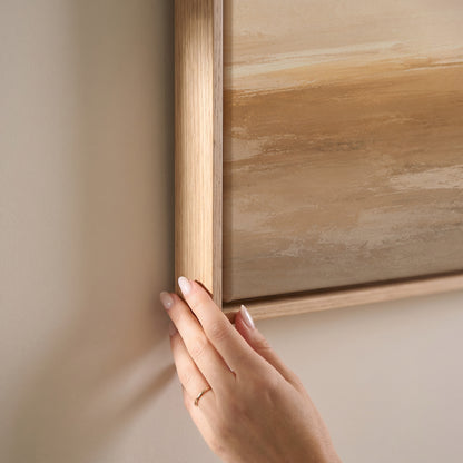 Wide pale sky over a soft ochre shoreline with light breaking along the horizon, horizontal canvas print