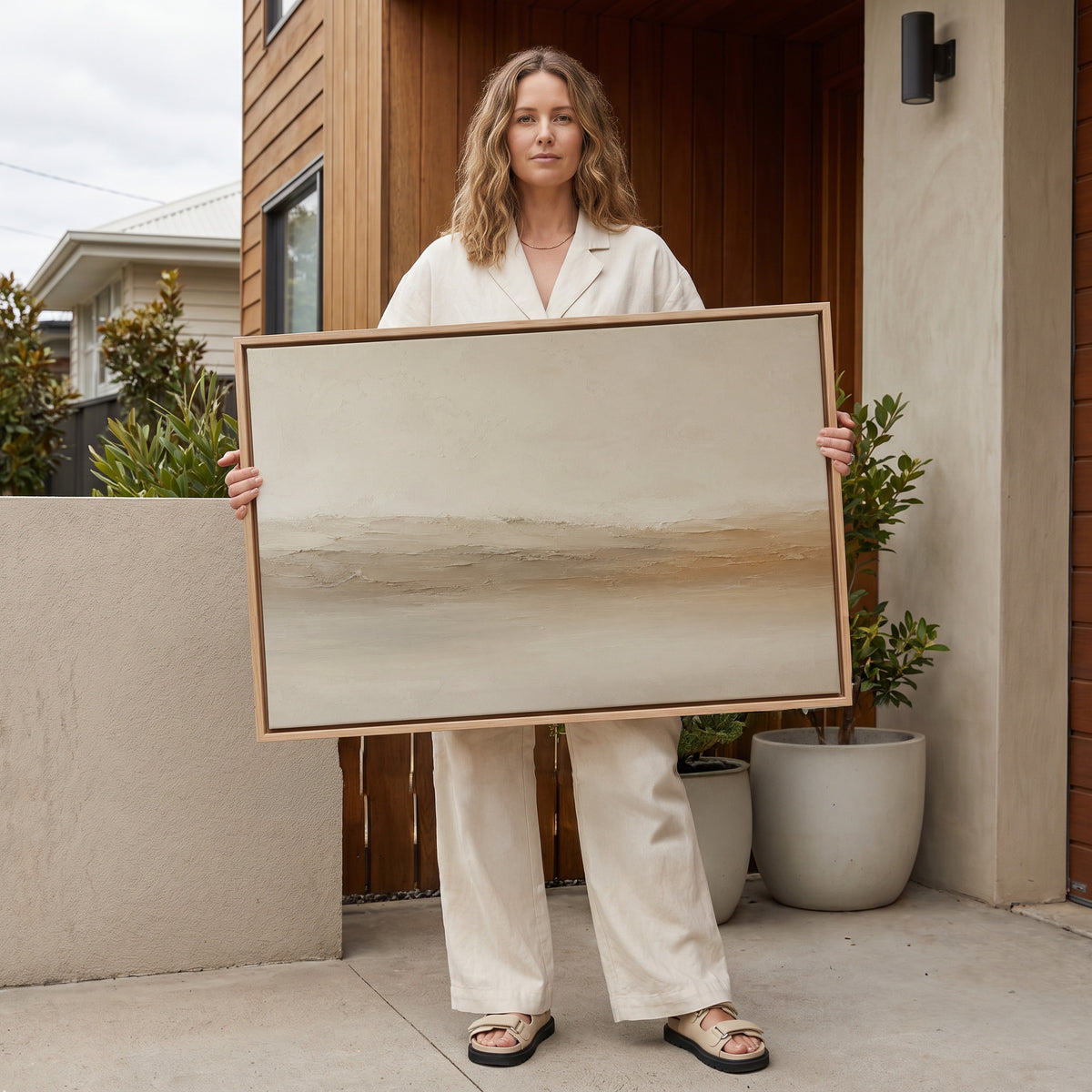 Warm neutral canvas wall art showing pale abstract landscape with a scraped ridge of cream and ochre across the middle