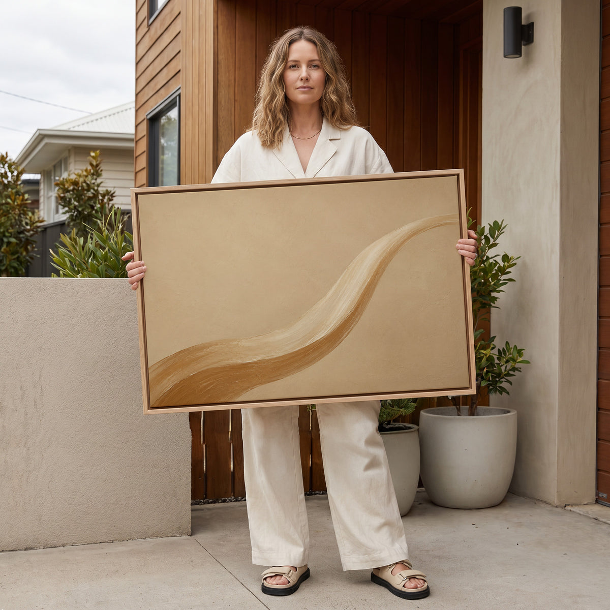Beige canvas wall art showing one long caramel and cream brushstroke sweeping across a warm sand ground