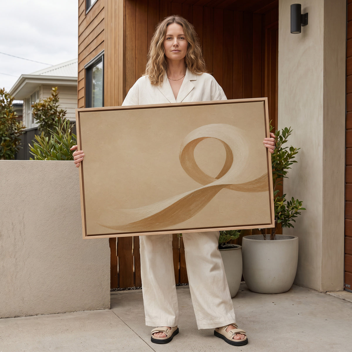 Wabi sabi canvas wall art showing a cream and caramel brushstroke curling into an open loop on a sand ground