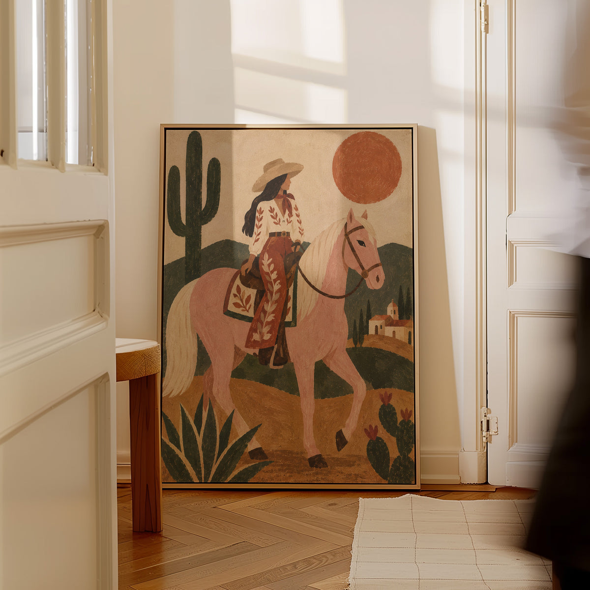 Boho canvas wall art showing cowgirl riding a pale rose horse past cacti under a red desert sun