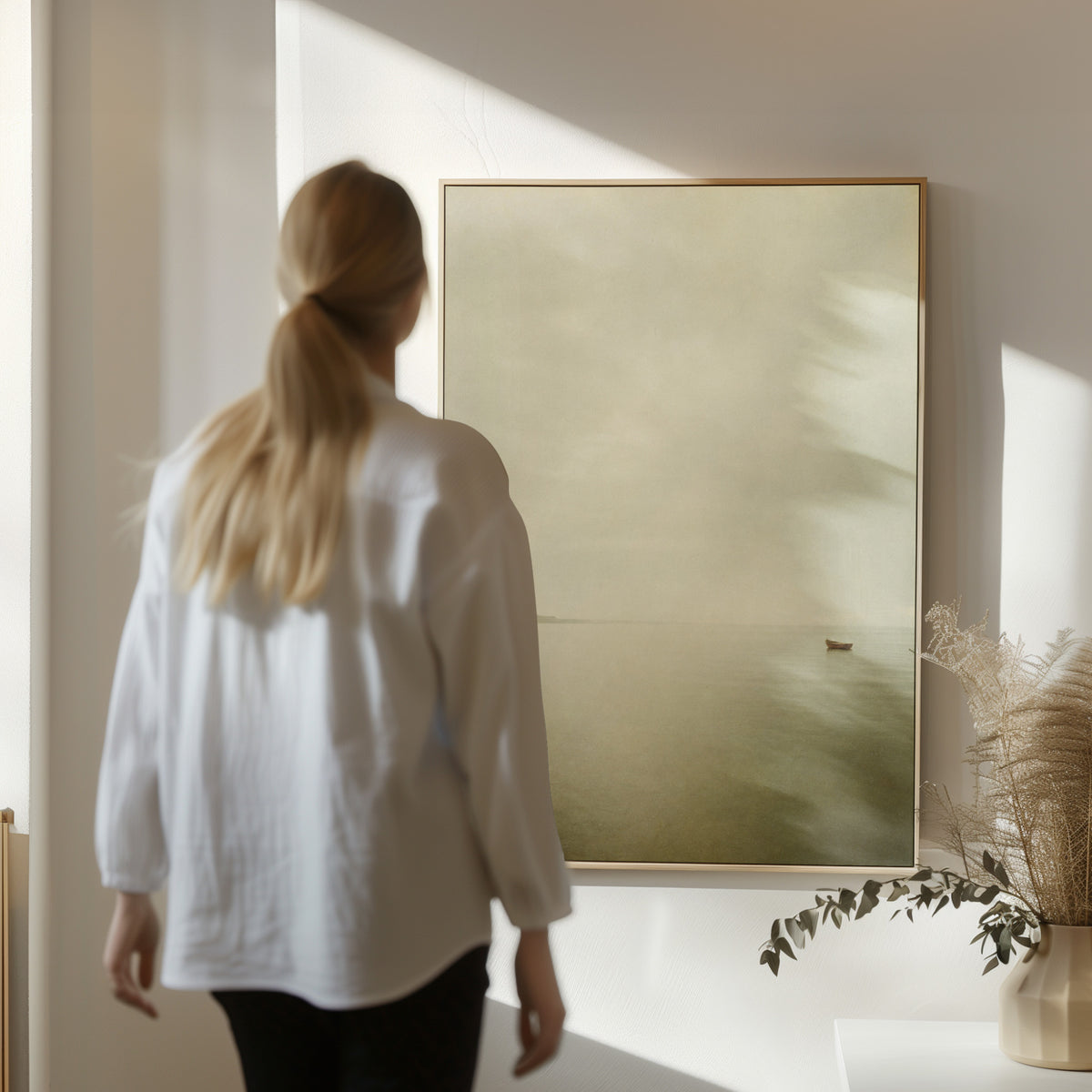 Misty sea canvas wall art showing a single small boat on flat pale water with a distant headland in mist