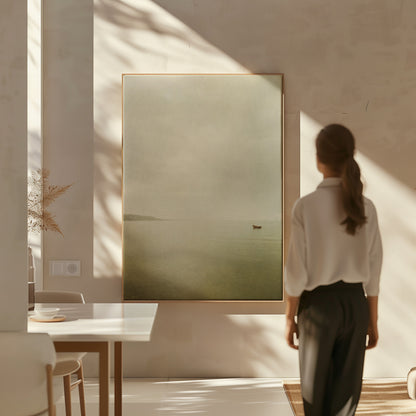 Beige canvas wall art showing a single small boat on flat pale water with a distant headland in mist