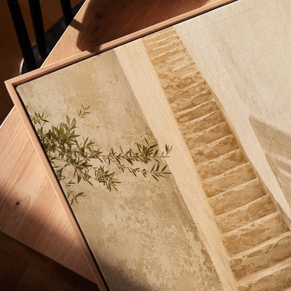 Narrow stone stairway between sunlit walls with a terracotta urn below, vertical canvas print