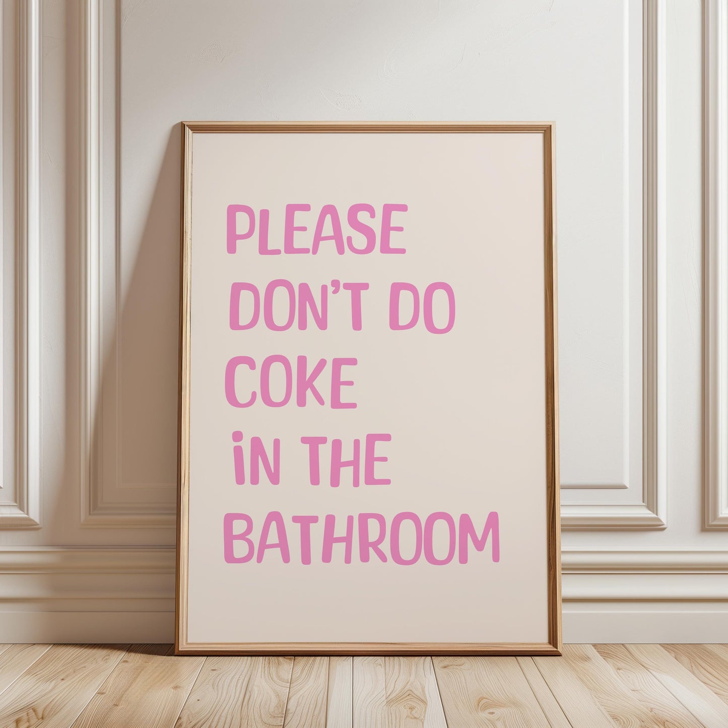 A framed poster with the text "PLEASE DON'T DO COCO IN THE BATHROOM" in pink letters.