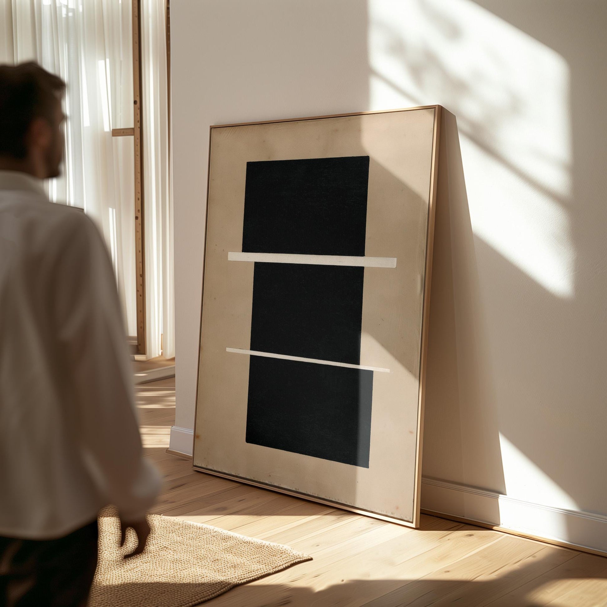 a person standing in a room with a large black and white abstract artwork displayed on the wall.