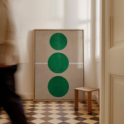 a large framed artwork with three green circles on a checkered floor, and a small wooden stool in the corner of the room.