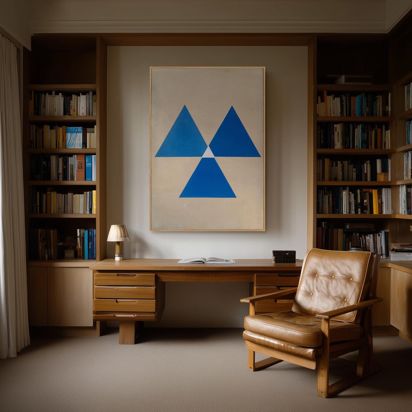 a cozy and well-organized home office with a large wooden desk, a comfortable leather chair, and a striking blue and white abstract artwork on the wall.