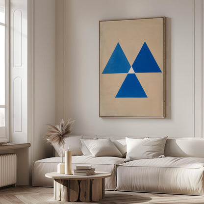 a modern living room with a large abstract painting featuring blue triangles on the wall. The room is furnished with a white sofa and a round wooden coffee table.