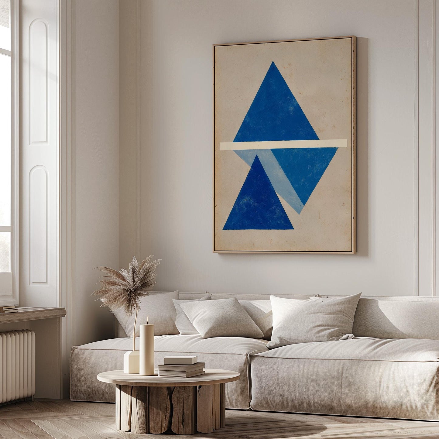 a modern living room with a large abstract painting featuring blue triangles on the wall. The room has a white sofa and a round wooden coffee table, creating a minimalist and elegant atmosphere.