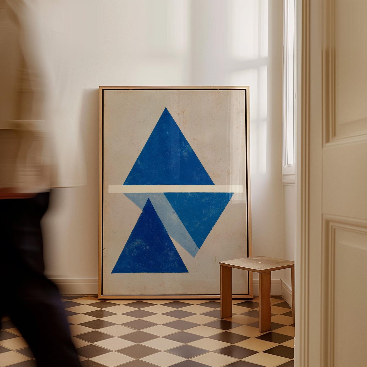 a large blue triangle on a white background, with a small wooden stool in the foreground.