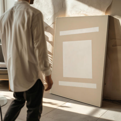 A person is standing in front of a large blank canvas, examining it.