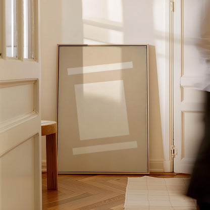 a large, abstract painting with a minimalist design, standing on a wooden floor in a room with a white door and a window.