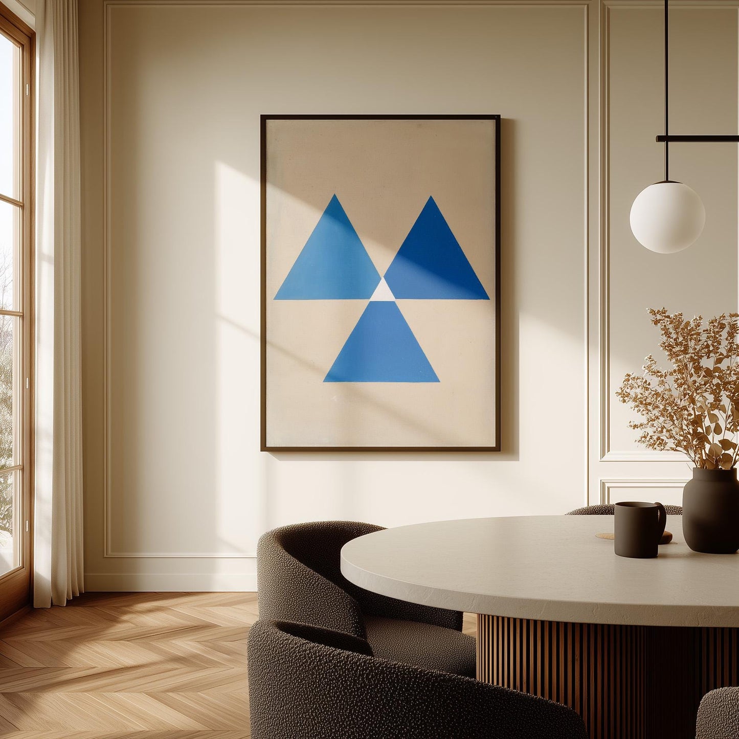 a modern dining room with a round table, a black chair, and a framed abstract artwork on the wall.
