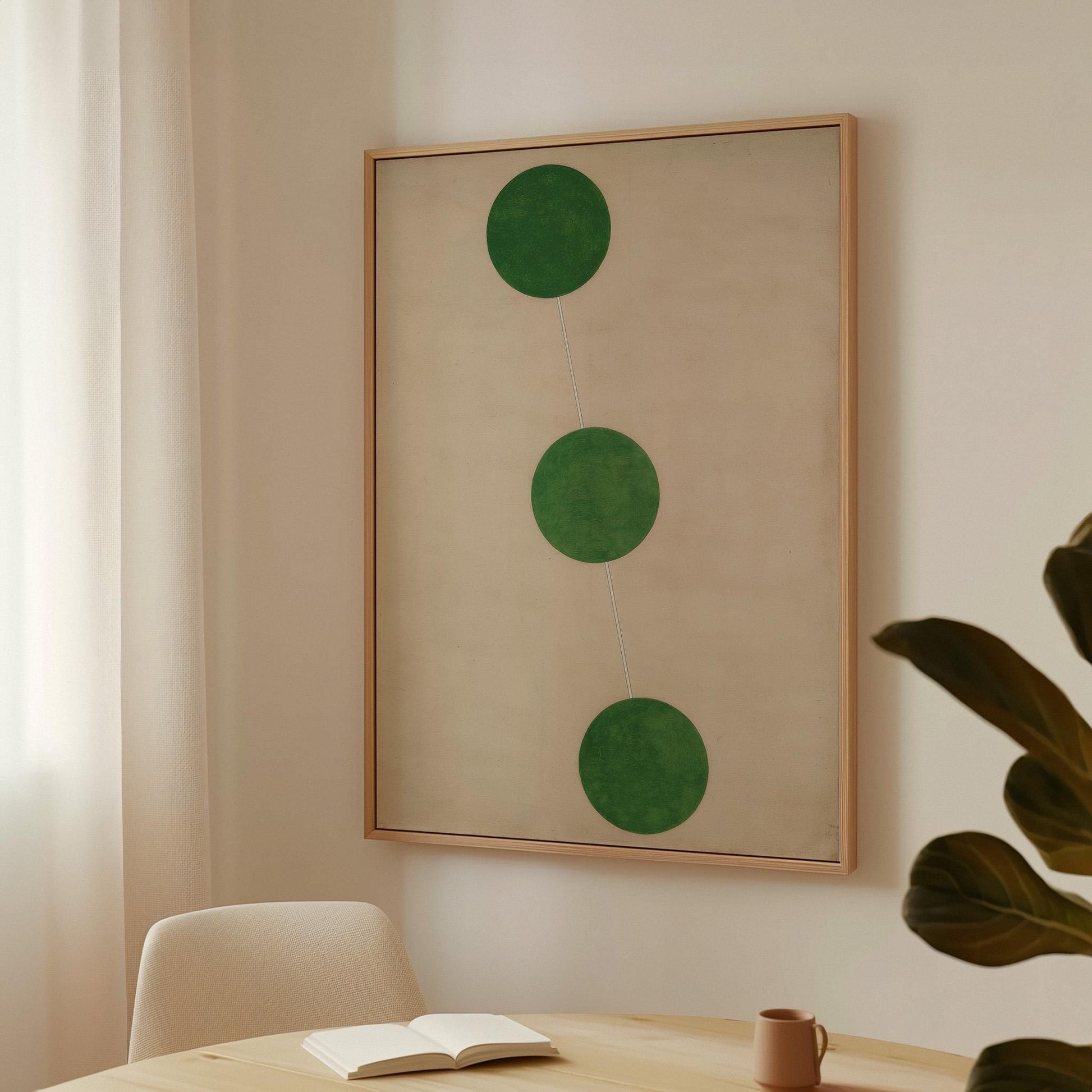 a minimalist interior design with a large framed artwork hanging on the wall, a white chair, and a small table with a book and a coffee cup on it.