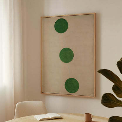 a minimalist interior design with a large framed artwork hanging on the wall, a white chair, and a small table with a book and a coffee cup on it.