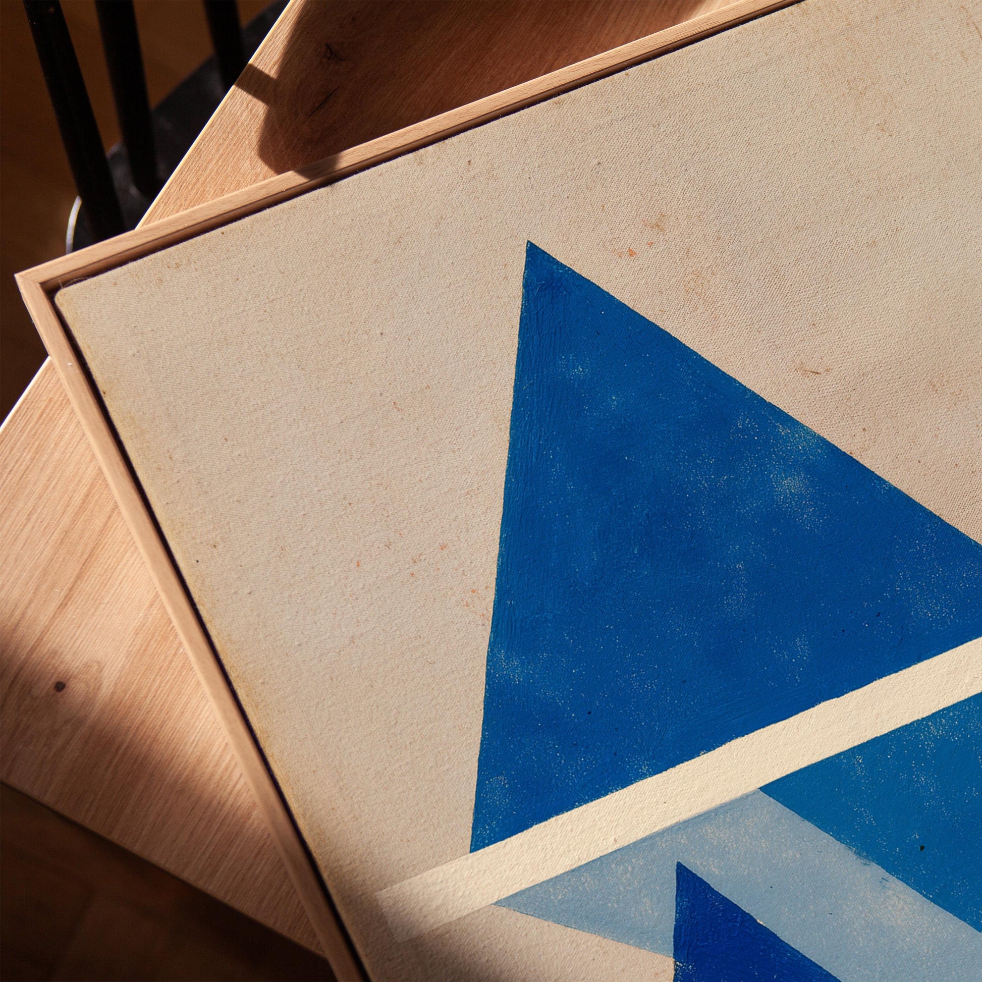 a close-up view of a painting with a blue triangle on a white background.
