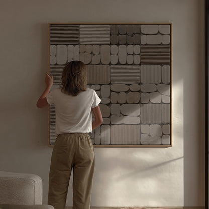 A person standing in front of a large abstract painting, examining it closely.
