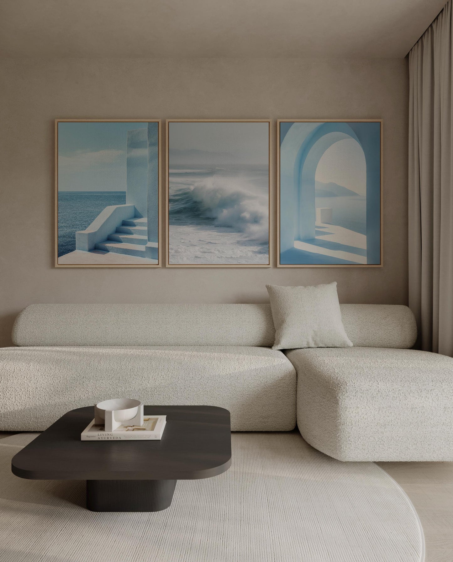 a modern living room with a white sofa, a black coffee table, and three framed pictures on the wall above the sofa.
