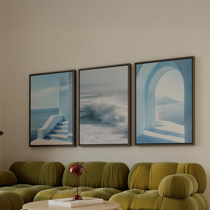 a living room with a green sofa and a red lamp on a table. Above the sofa, there are three framed pictures hanging on the wall, depicting a staircase, a wave, and an archway.