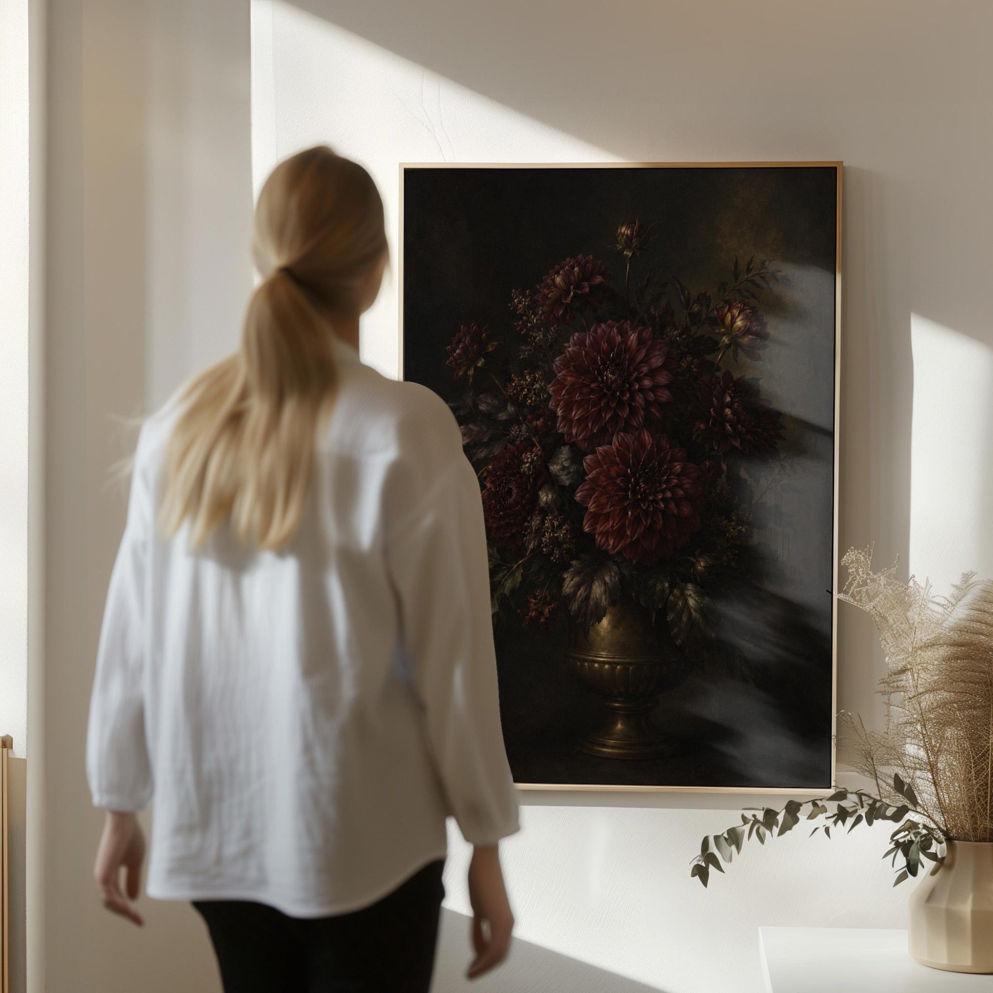 Burgundy dahlias in a brass urn against darkness, canvas print displayed on a neutral wall in a styled interior