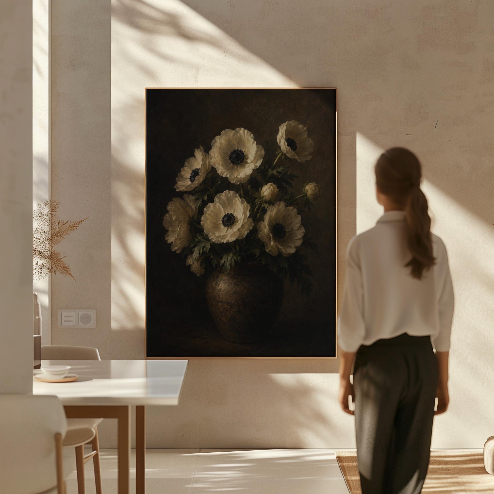White anemones with dark centres in an earthen vase, canvas wall art hanging in a calm, modern living space