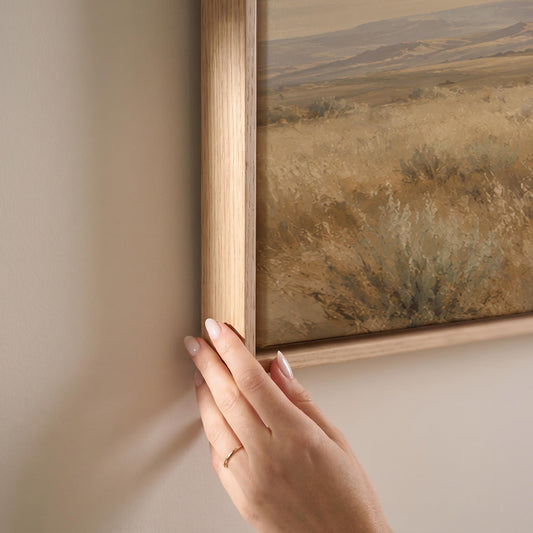 Lone white horse cantering across open prairie under a big sky, canvas print shown at full size in a light-filled bedroom