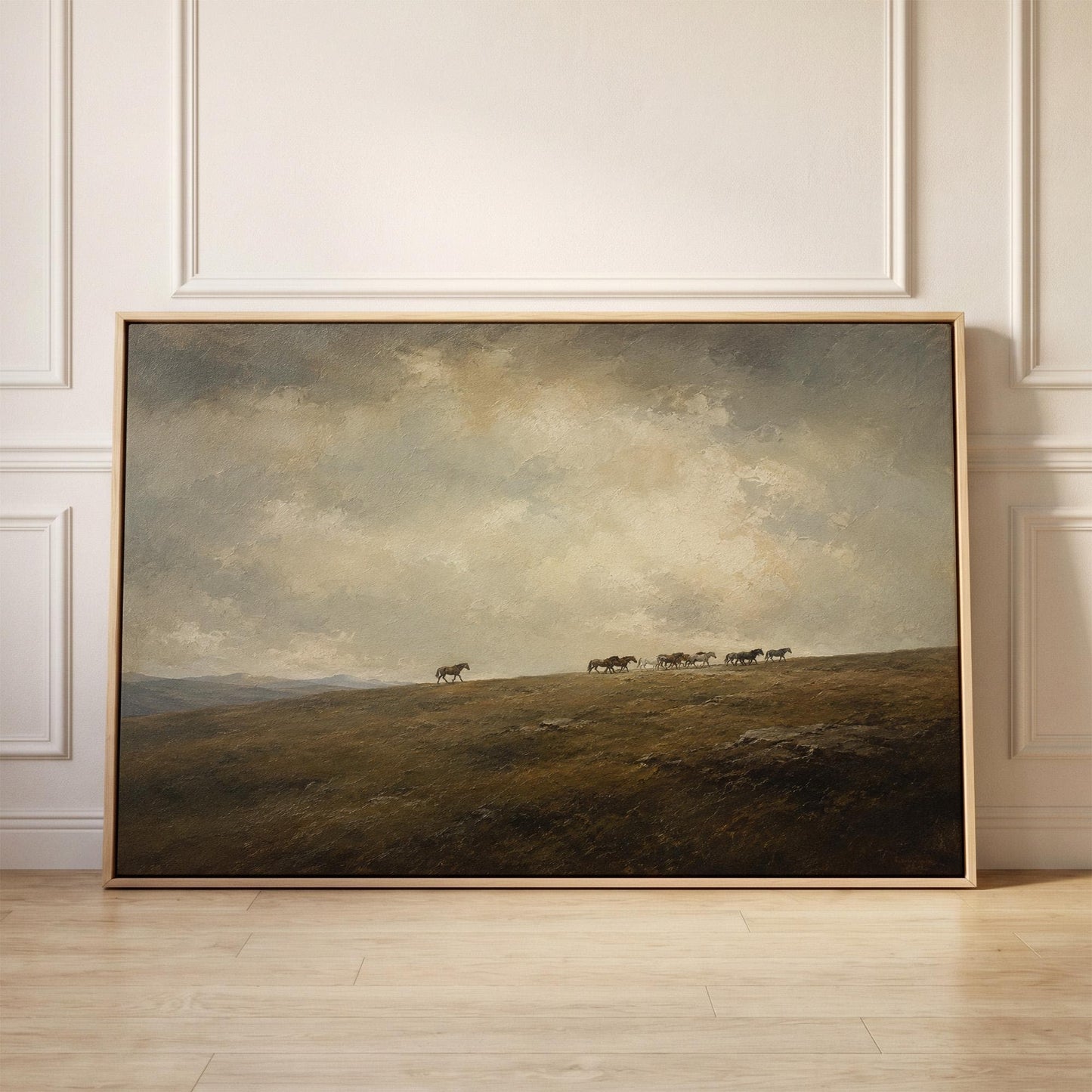 Distant herd of horses crossing a ridge under a vast cloudy sky, canvas print held up against a sunlit bedroom wall