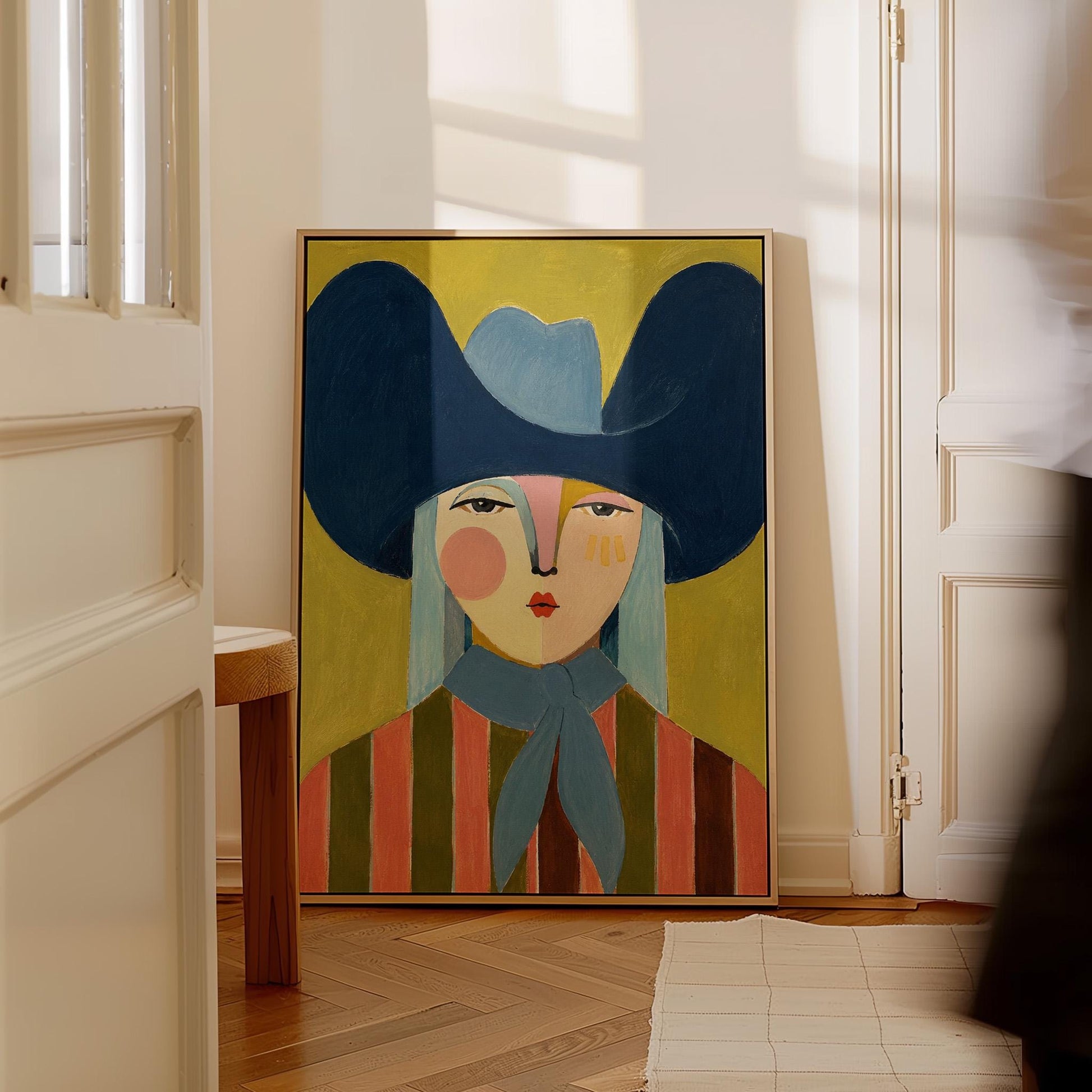 Folk cowgirl in an oversized navy hat and blue neckerchief on mustard, canvas wall art hanging in a calm, modern living space