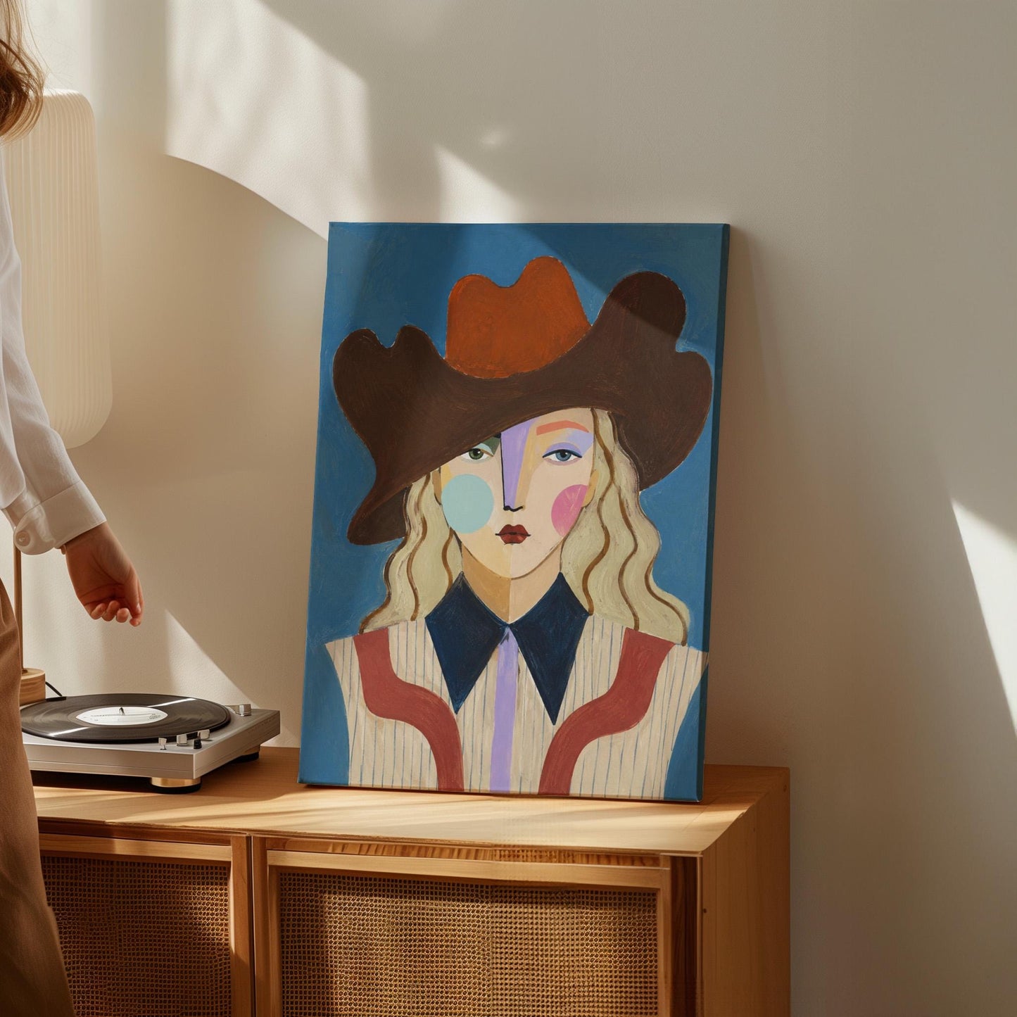 Blonde cowgirl in a rust cowboy hat with a cubist face on deep blue, canvas print on a quiet wall in a considered interior