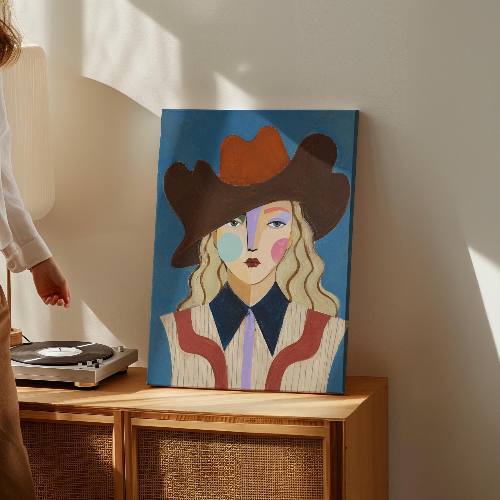 Blonde cowgirl in a rust cowboy hat with a cubist face on deep blue, canvas print on a quiet wall in a considered interior