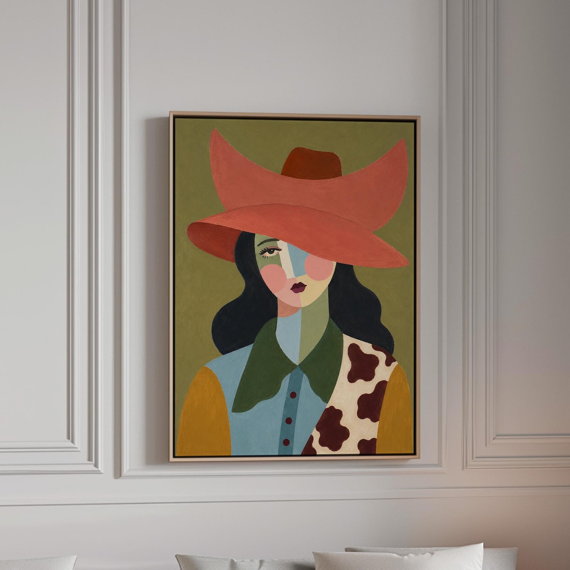 Cowgirl in a wide coral hat with a cubist face and cow-print collar on olive, canvas print in a bright room with natural daylight