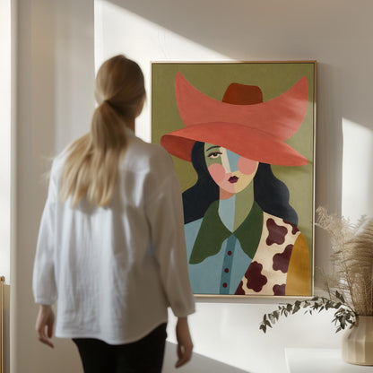 Cowgirl in a wide coral hat with a cubist face and cow-print collar on olive, canvas print shown to scale in a furnished room