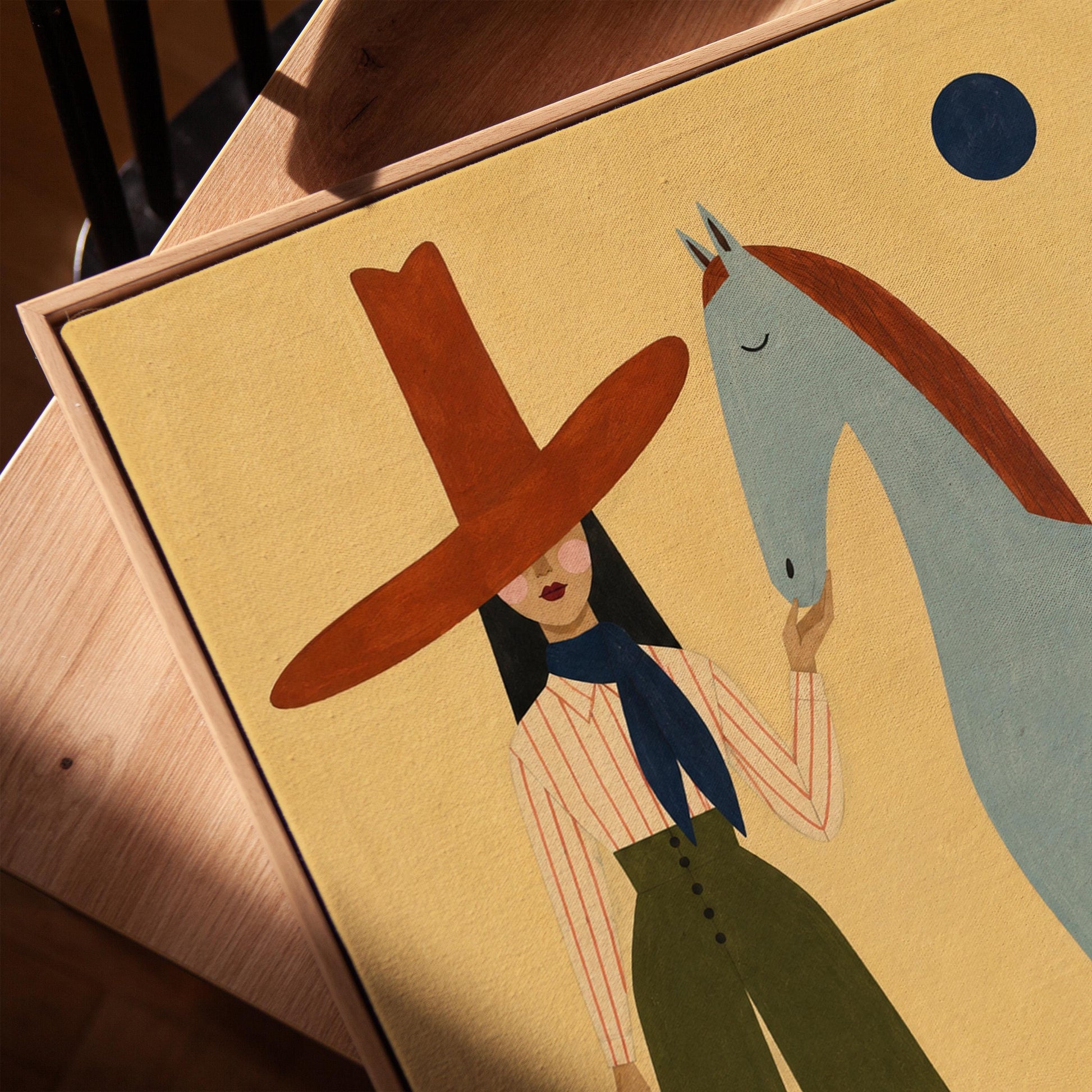Cowgirl in a red hat standing beside a pale blue spotted horse on warm yellow, canvas print in a warm, minimally styled interior