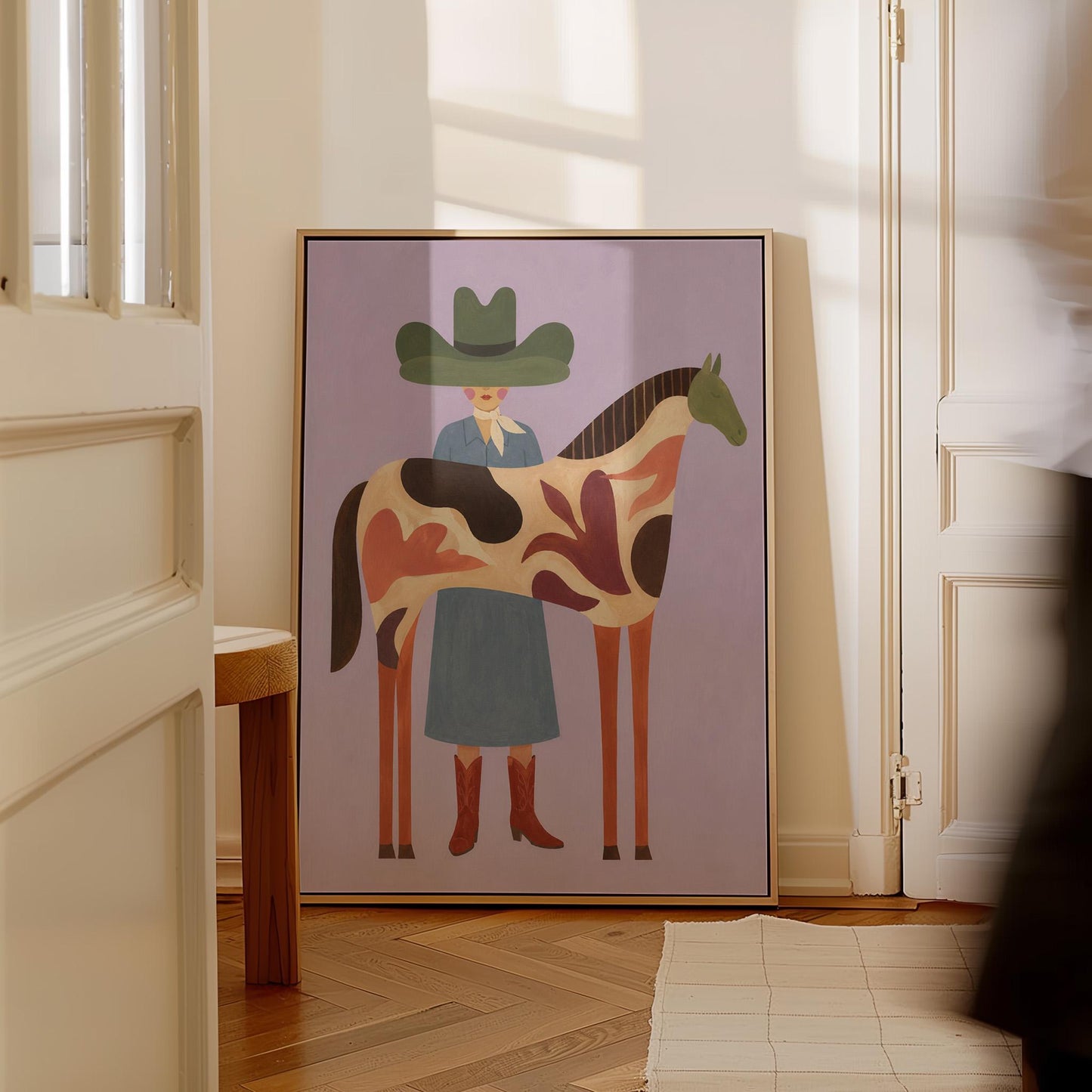 Cowgirl in a green hat beside a tall patterned horse on soft lilac, canvas print shown to scale in a furnished room