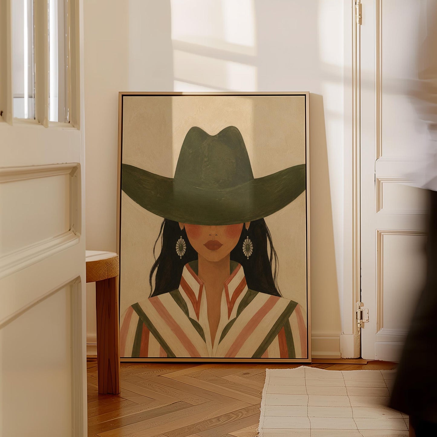 Cowgirl under a deep green hat with concho earrings and a striped western shirt, canvas print on a quiet wall in a considered interior