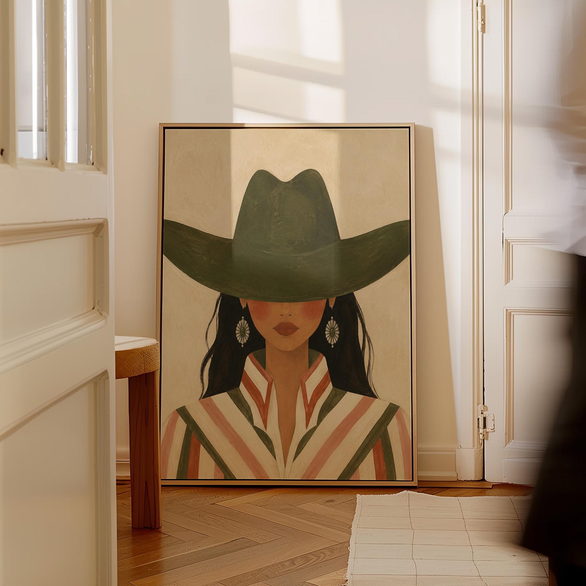 Cowgirl under a deep green hat with concho earrings and a striped western shirt, canvas print on a quiet wall in a considered interior