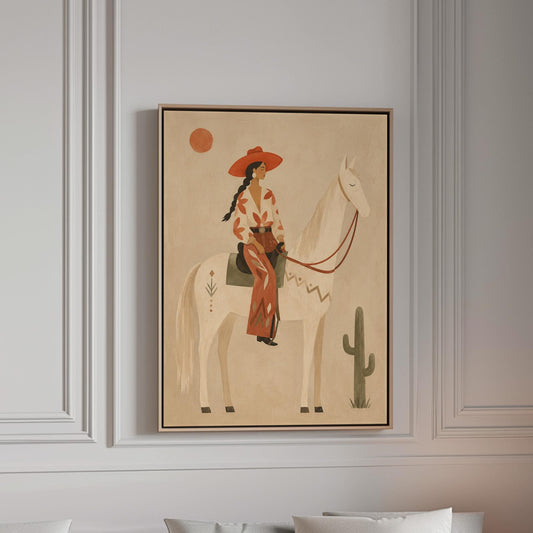 Cowgirl in a red hat sitting on a white horse beside a cactus in warm sand, canvas print in a bright room with natural daylight