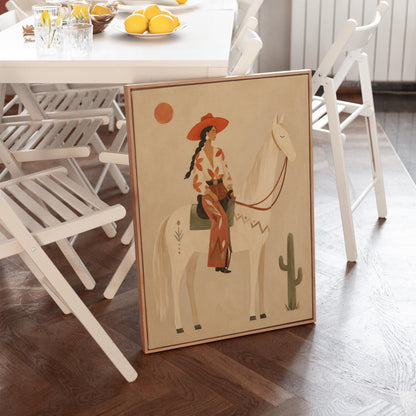 Cowgirl in a red hat sitting on a white horse beside a cactus in warm sand, canvas wall art seen in a warm interior with natural light