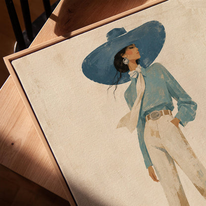 Full-figure cowgirl in a wide teal hat, blouse and boots with cream trousers, canvas print in a warm, minimally styled interior