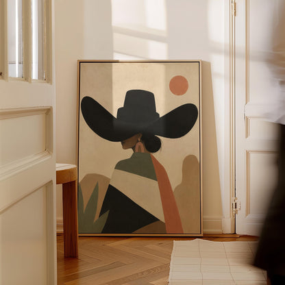 Cowgirl seen from behind in a large black hat and serape under a desert sun, canvas print hanging in a calm, modern living space