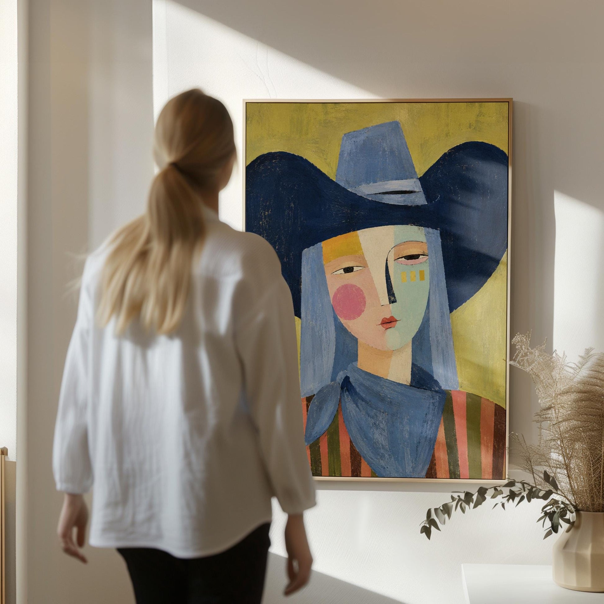 Cubist cowgirl with a big navy hat and multicolor face on olive yellow, canvas print presented in a light, minimal room