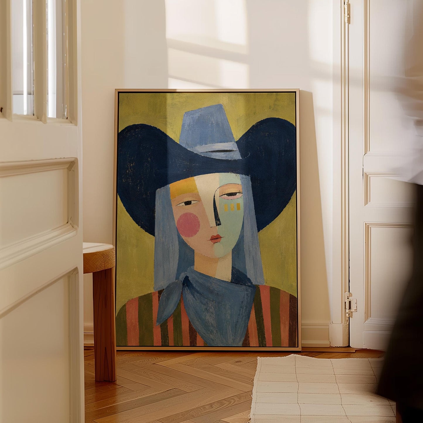 Cubist cowgirl with a big navy hat and multicolor face on olive yellow, canvas wall art styled against a soft white wall