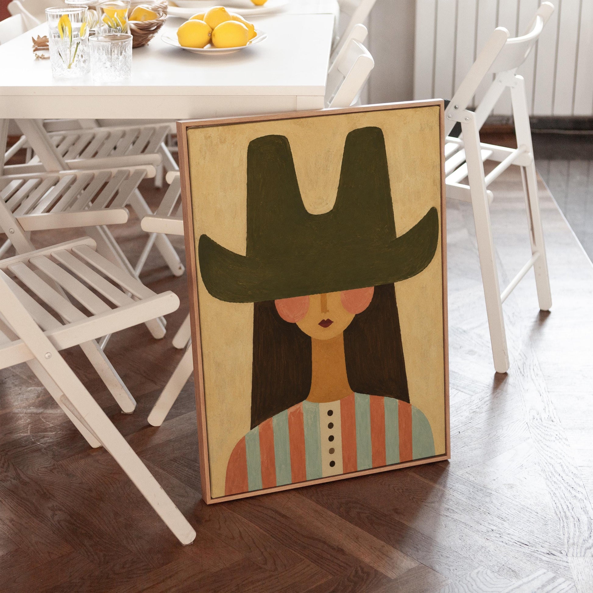 Folk cowgirl in a big green hat and striped shirt with long dark hair, canvas wall art seen in a warm interior with natural light
