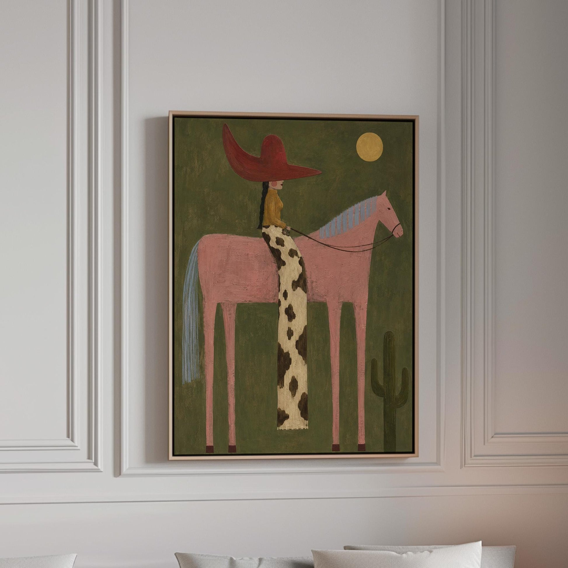 Cowgirl in a red hat riding a tall pink horse past a cactus under the moon, canvas print in a bright room with natural daylight