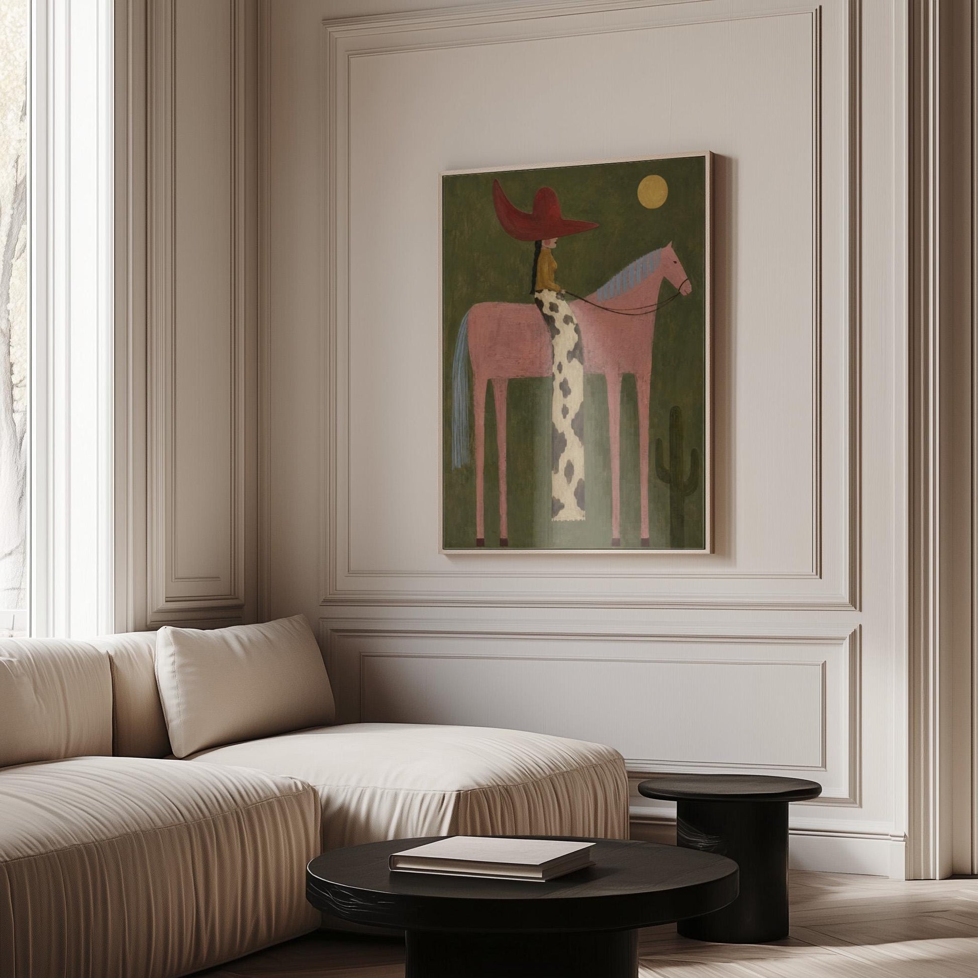 Cowgirl in a red hat riding a tall pink horse past a cactus under the moon, canvas print seen in a warm interior with natural light